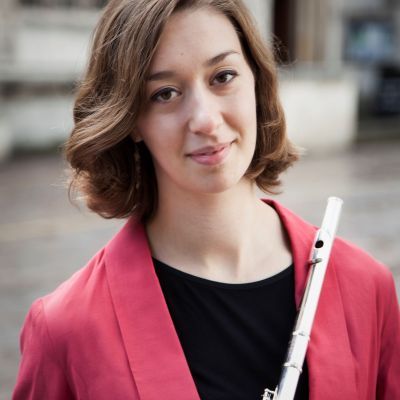 Rosie Bowker - staff at Guildhall School - posing with flute in city street